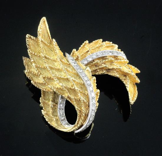 An early 1970s textured 18ct gold and diamond set scrolling laurel leaf brooch, 47mm.